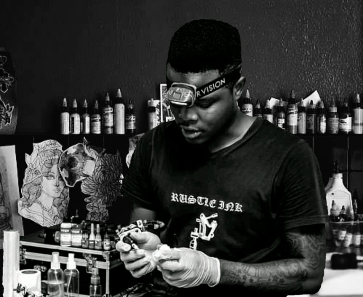 Rustle Ink artist at the workstation preparing a tattoo machine